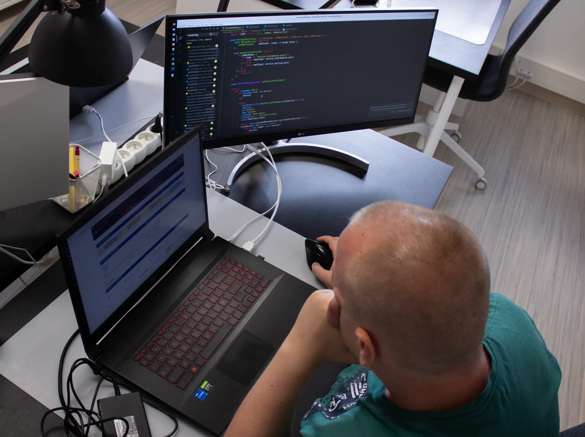 Poste de travail : éditeur de code sur l’écran, application métier sur l’ordinateur.